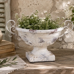 Cremiger Terrakotta‑Übertopf für dekorative Arrangements.